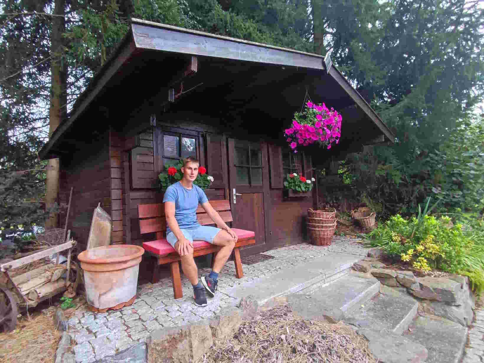 Bild Moritz, auf Bank vor Hütte sitzend